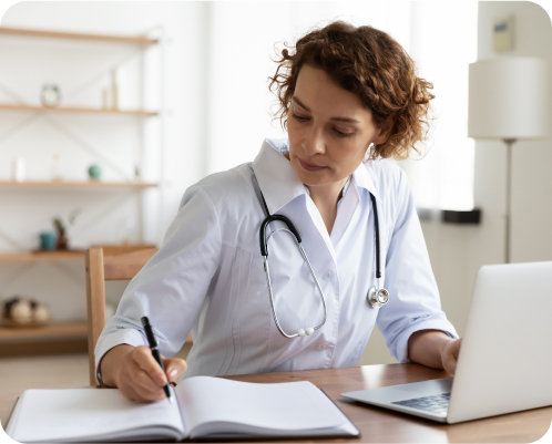 a female doctor attentively taking notes from a laptop 